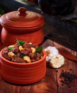 A red clay pot filled with savory meat & aromatic spices, creating a Delicious culinary masterpiece