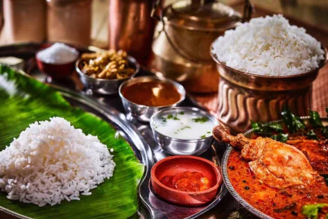 A pleasing and delicious platter of non-veg meals with rice, gravy, curries, chops, buttermilk, salt