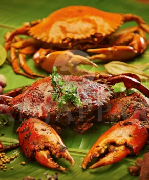 An appetizing crab fry, artfully placed on a banana leaf, covered by an enticing array of food items