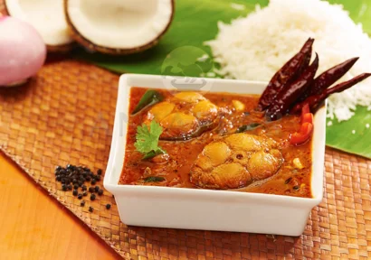 A bowl of aromatic fish curry showcasing the best flavors along with rice served in banana leaf.